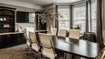 A conference room with a long table and chairs.